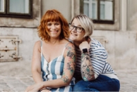 Miriam und Anna sitzen fröhlich in einer sommerlichen Brise.